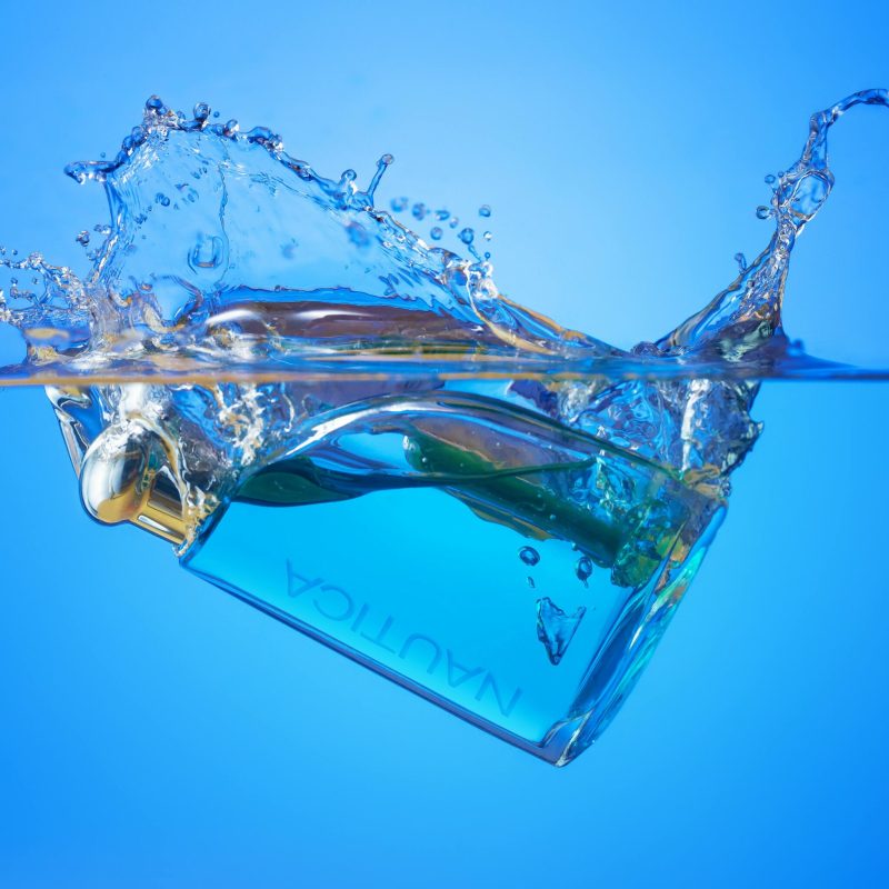 Captivating image of a perfume bottle creating a dynamic splash effect in water.